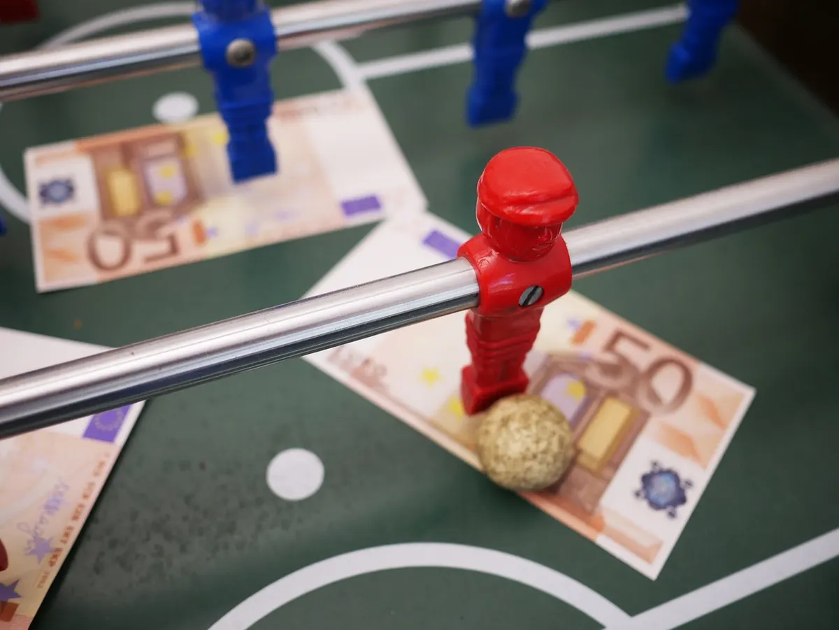 Calcio balilla e banconote, simbolo delle scommesse sportive